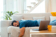© simona - The exhausted man fell asleep on the comfortable sofa in the modern living room, without energy after a hard day at work. Tired, depressed and unmotivated Caucasian male taking a nap on sofa at home