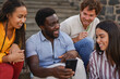 © Sabrina - Group of multiracial young people using mobile phone in the city - Friendship, diverse ethnic and lifestyle concept