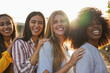 © Sabrina - Group of multiracial girls smiling in front of camera outdoor during sunset time - International women, diversity and friendship concept
