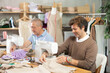 © JackF - Male tailors sitting in a sewing workshop and working on tailoring clothes for a client