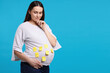 © New Africa - Thoughtful pregnant woman with notes with different names on her belly against light blue background, space for text