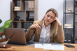 © New Africa - Woman feeling fatigue at wooden desk in office