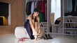 © stockbusters - Graceful brunette wearing heels sitting dressing room. Solo lady sampling shoes