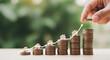 © Taky - Real Estate Investment Growth Concept with House Models on Increasing Coin Stacks