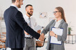 © Pixel-Shot - Male business mediator and clients shaking hands in office
