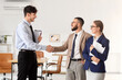 © Pixel-Shot - Business mediator with clients shaking hands in office