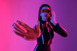 © Pixel-Shot - Young woman in VR glasses using virtual screen on pink background, closeup