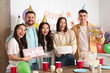© Pixel-Shot - Group of young friends with cake and gifts celebrating Birthday at party in kitchen