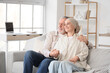 © Pixel-Shot - Mature woman after chemotherapy with her husband hugging on sofa at home