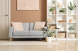 © Pixel-Shot - Cozy sofa, houseplant and shelving unit in interior of living room