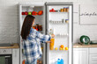 © Pixel-Shot - Young Asian woman with bottle of juice near open fridge in kitchen
