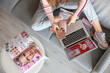 © Pixel-Shot - Woman with credit card and makeup products shopping online on sofa at home, top view