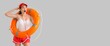 © Pixel-Shot - Surprised female beach rescuer with lifebuoy on grey background with space for text