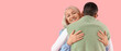 © Pixel-Shot - Young man with his mother hugging on pink background