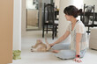 © Jirawatfoto - Calm asian woman sitting on floor inside comfortable home playing with friendly pet cat feeling happy promoting good mental health and daily wellness