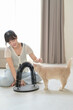 © Jirawatfoto - Happy asian woman sitting comfortably on floor at home enjoying wellness and good mental health benefits while playing with friendly pet cat indoors