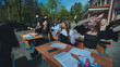 © Довидович Михаил - Happy students at outdoor desks raising their hands to celebrate the end of the school day