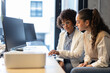 © BusinessClass by W61 - Businesswoman mentoring colleague during office discussion at workspace