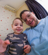 © phpetrunina14 - Smiling father and toddler taking a wide-angle selfie at home.