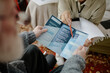 © Seventyfour - Caucasian man in wheelchair receiving informational brochure from young adult Black woman social worker during consultation, both focusing on printed materials in indoor setting