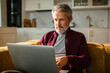 © Marko Geber - Mature man working on laptop in home kitchen