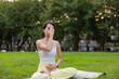 © leungchopan - Female enjoying peaceful breathing meditation session in park