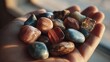 © Crocodilchik - collection of colorful pebbles in hand with soft natural lighting, calm nature background, peaceful and minimal composition
