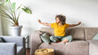 © Davide Angelini - Happy afro american woman relaxing on the sofa at home - Smiling girl enjoying day off lying on the couch - Healthy life style, good vibes people and new home concept