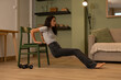© sutulastock - Fit woman performing triceps dip exercise using chair at home, bodyweight strength training for arms, shoulders and core during indoor fitness workout in living room