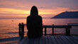 © Ayub Ali - Person sitting on a dock watching sunset over calm water