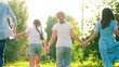© Victoriia - Mom dad, children, holding hands, run, play fun in city park, summer. Slow motion. Family, mom dad, son daughter running together, happy childhood, free people. Happy family. Family game concept.