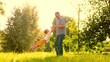 © Victoriia - Father, little son play carefree in fresh air. Family weekend in nature. Dad plays with baby, holding happily smiling son in arms, park, lawn. Father leads child by hand in circle, play on green lawn
