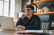 © InsideCreativeHouse - Office, laptop and man with glasses, happy and risk assessment for investment proposal and research. Business, financial analyst and person with tech for asset management, smile and budget review