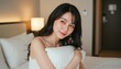 © AiPhoto - 枕を抱きしめてベッドで横を向くキャミソール姿の若い女性