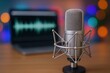 © The Little Hut - Studio Microphone with Laptop Displaying Audio Waveform for Podcasting and Recording, Set Against Bokeh Lights