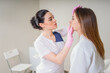 © Maria - Professional cosmetician examining face skin of girl in clinic of esthetic cosmetology