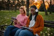© Jelena - Diverse women friends enjoying technology in a park
