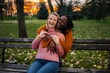 © Jelena - Happy diverse lesbian couple embracing in autumn park