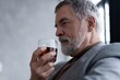 © opolja - Confident mature businessman chilling relaxing drinking enjoying whiskey after work.