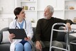 © New Africa - Care worker with clipboard talking to senior man indoors