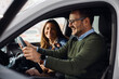 © Drazen - Happy couple testing new vehicle at car dealership.