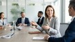 © TechVision Studio - Woman in grey suit actively gesturing and speaking during a business meeting in a bright, modern conference room, colleagues in background, engaged in discussion at a wooden table, teamwork, 200