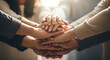© Itshamza - A group of diverse people stacking their hands together in unity and teamwork