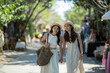 © apichat - Friends women walking holding hands street market