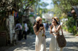 © apichat - Asian women friends traveling walking talking laughing outdoors