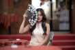 © apichat - Asian woman wearing qipao holding hand fan