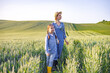 © sofiko14 - A woman and a young girl stand in a vast field of wheat, looking towards the horizon under a clear sky
