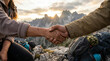 © Rohan Katwe - Two hikers shake hands on a rocky mountain ridge at sunset, symbolizing teamwork, trust and accomplishment after an adventurous hike in the wilderness surrounded by dramatic landscape light.