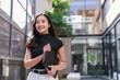 © crizzystudio - Young asian businesswoman smiling holding tablet walking outside