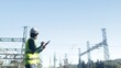 © DawDunia - Electrical engineer checking power grid infrastructure, inspecting high voltage electricity substation equipment with a digital tablet for maintenance and energy distribution management